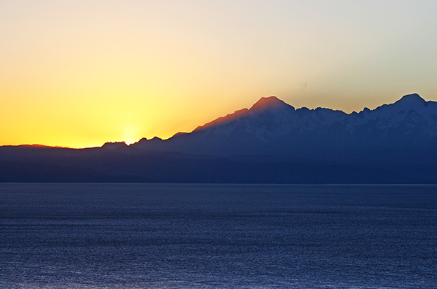 Рассвет солнца над вершинами Кордельера Реал и озером Титикака